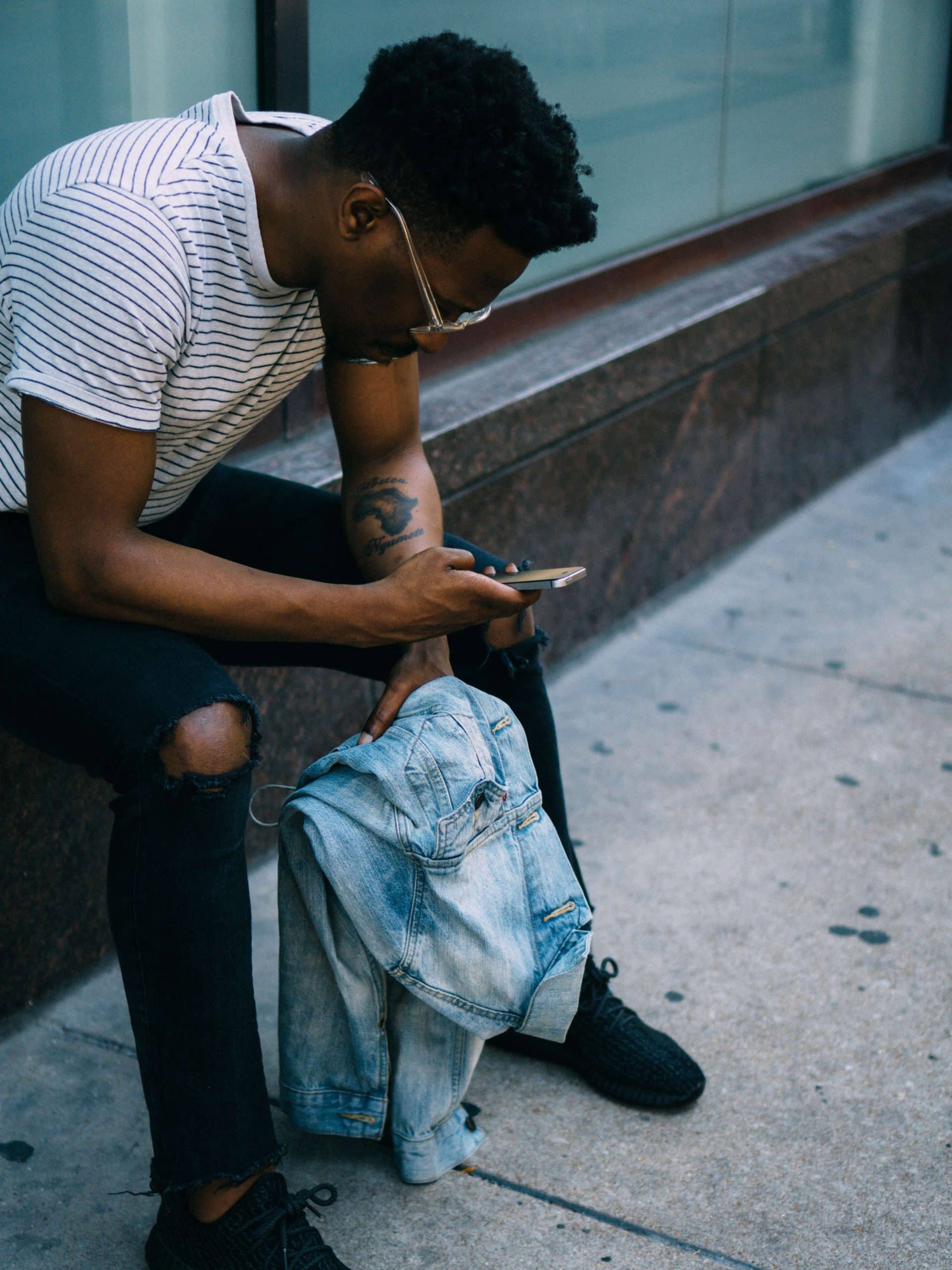 Man sitting outside looking at phone