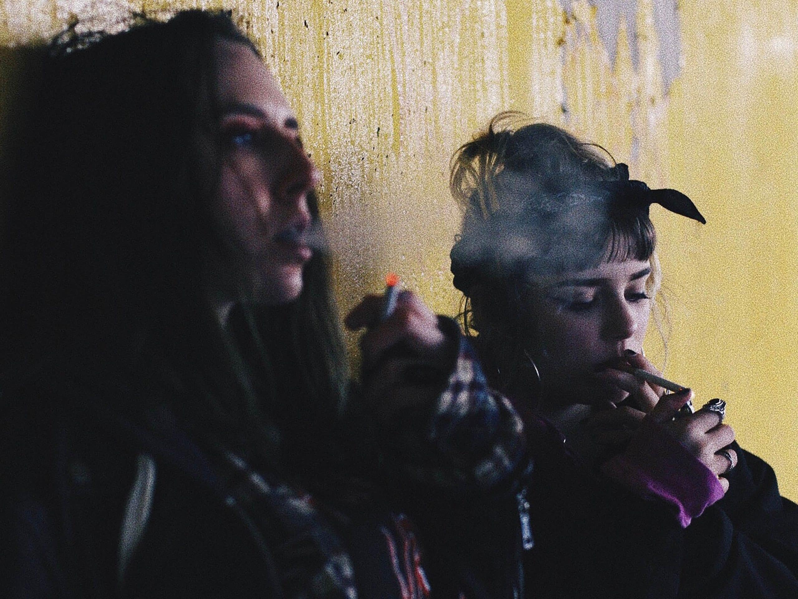 Two women doing drugs in an alley