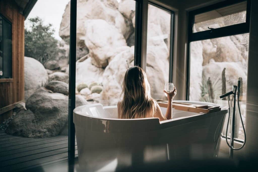 Woman in bathtub holding a glass